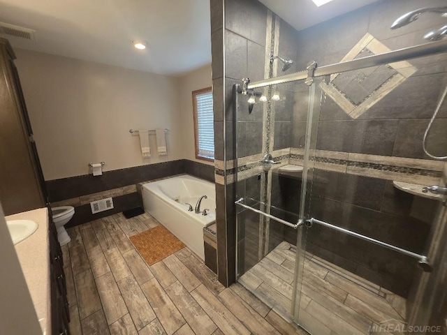 7283 S Fork Dr, Swan Creek, MI 48473 - bathroom with a garden tub, vanity, wood finished floors, and a stall shower