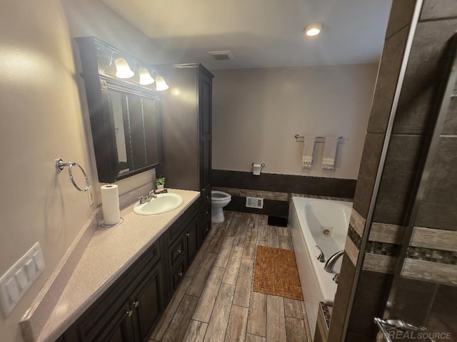 7283 S Fork Dr, Swan Creek, MI 48473 - full bath featuring a tub with jets, vanity, and wood finished floors