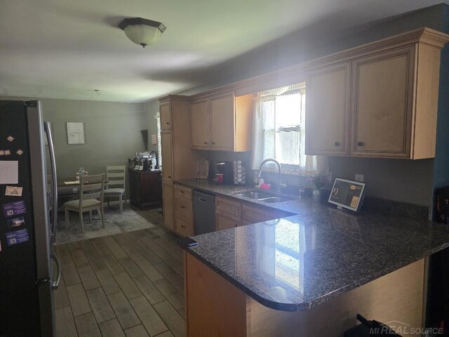 7283 S Fork Dr, Swan Creek, MI 48473 - kitchen with stainless steel appliances, a peninsula, dark wood-style floors, dark stone counters, and a breakfast bar area