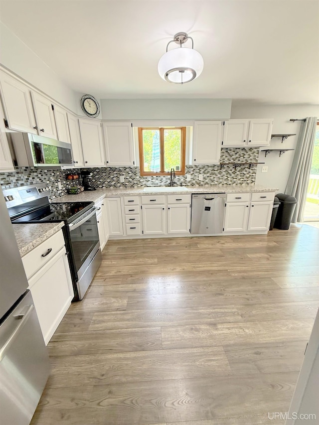 21805 Number 9 Rd, Hancock, MI 49930 - kitchen featuring stainless steel appliances, plenty of natural light, white cabinetry, and decorative backsplash