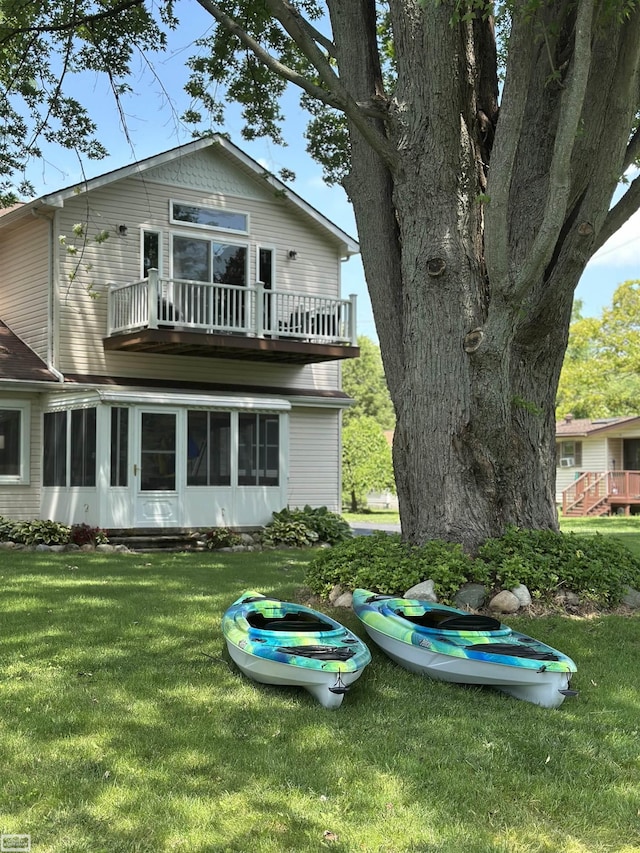 2100 Michigan St, Algonac, MI 48001 - back of property with a balcony, a lawn, and a sunroom