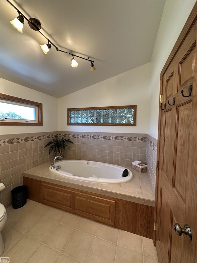 2100 Michigan St, Algonac, MI 48001 - bathroom with tile walls, a bath, vaulted ceiling, tile patterned floors, and a wainscoted wall