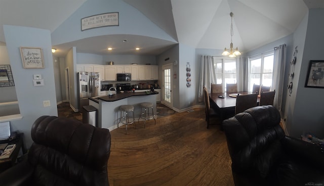 11639 State Rd, Nunica, MI 49448 - dining area featuring vaulted ceiling, a chandelier, and dark wood-style floors