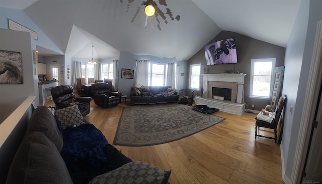 11639 State Rd, Nunica, MI 49448 - living room with lofted ceiling, light wood-style flooring, a fireplace with raised hearth, and a chandelier