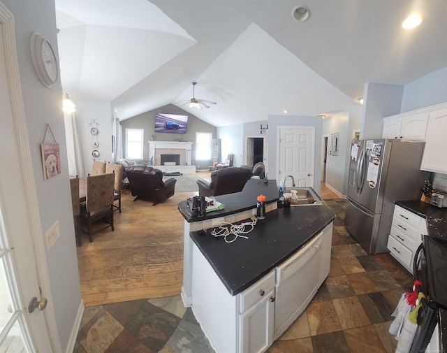11639 State Rd, Nunica, MI 49448 - kitchen featuring a center island with sink, dark countertops, stone tile flooring, white dishwasher, and white cabinetry