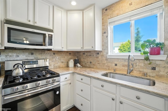 31222 Settlers Way Dr, Flat Rock, MI 48134 - kitchen with appliances with stainless steel finishes, white cabinetry, decorative backsplash, and light stone countertops
