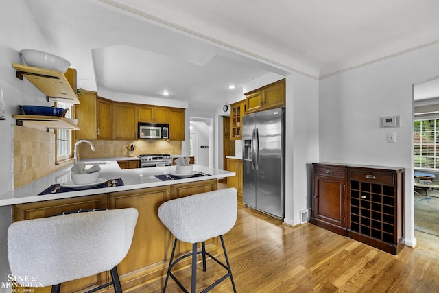 1344 Torrey Rd, Grosse Pointe Woods, MI 48236 - kitchen with appliances with stainless steel finishes, light wood-type flooring, open shelves, a peninsula, and decorative backsplash