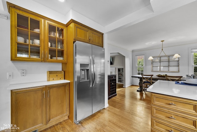 1344 Torrey Rd, Grosse Pointe Woods, MI 48236 - kitchen featuring stainless steel fridge with ice dispenser, brown cabinets, glass insert cabinets, light countertops, and light wood-style flooring