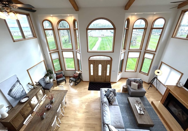 10125 Saint John Dr, Algonac, MI 48001 - living area with a ceiling fan, a towering ceiling, beam ceiling, light wood-style floors, and a fireplace