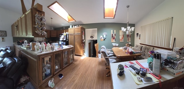 55305 Fairchild Rd, Macomb, MI 48042 - kitchen with vaulted ceiling, a chandelier, light wood-style flooring, freestanding refrigerator, and decorative light fixtures