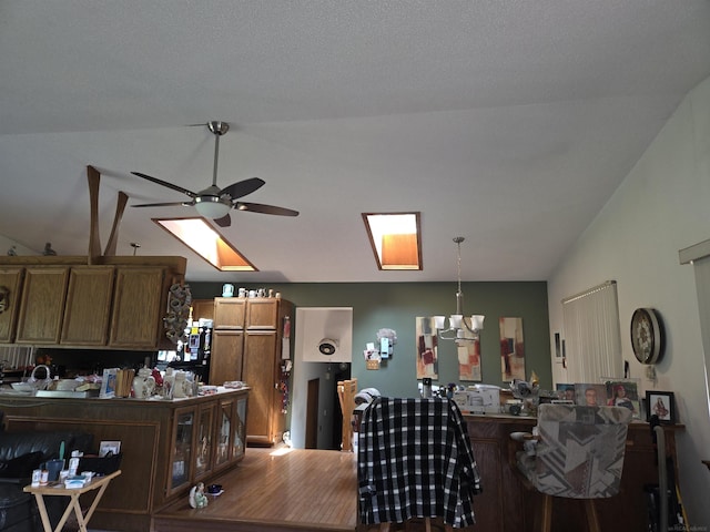 55305 Fairchild Rd, Macomb, MI 48042 - kitchen with ceiling fan, lofted ceiling, brown cabinets, hanging light fixtures, and a chandelier