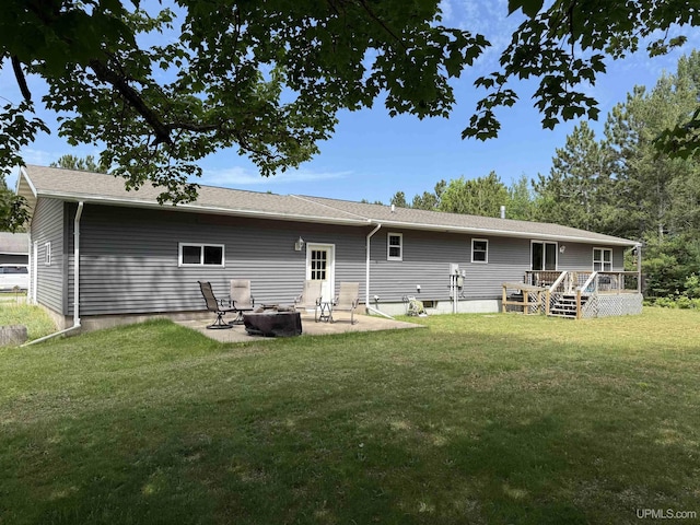 N7722 Candy Cane Rd, Munising, MI 49862 - back of property with a deck, a fire pit, a lawn, and a patio area