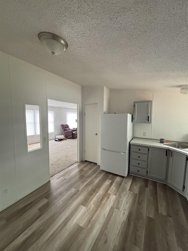 2299 Bart St, Croswell, MI 48422 - kitchen featuring freestanding refrigerator, gray cabinetry, wood finished floors, a textured ceiling, and light countertops