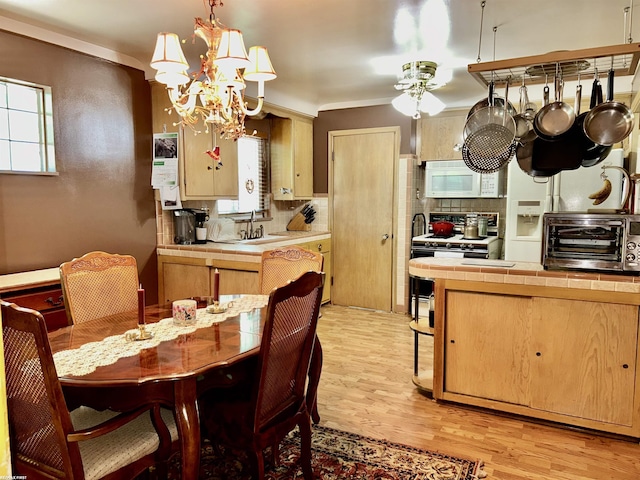 23311 Courtland Ave, Eastpointe, MI 48021 - dining space with light wood-type flooring, healthy amount of natural light, a chandelier, a ceiling fan, and ornamental molding
