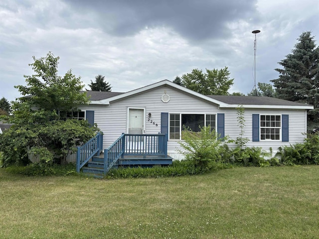 2266 Bart St, Croswell, MI 48422 - manufactured / mobile home featuring a front lawn, a shingled roof, and a deck