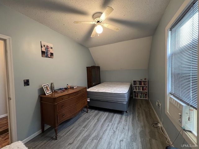 608 W Onota St, Munising, MI 49862 - bedroom with wood finished floors, a textured ceiling, lofted ceiling, a ceiling fan, and cooling unit