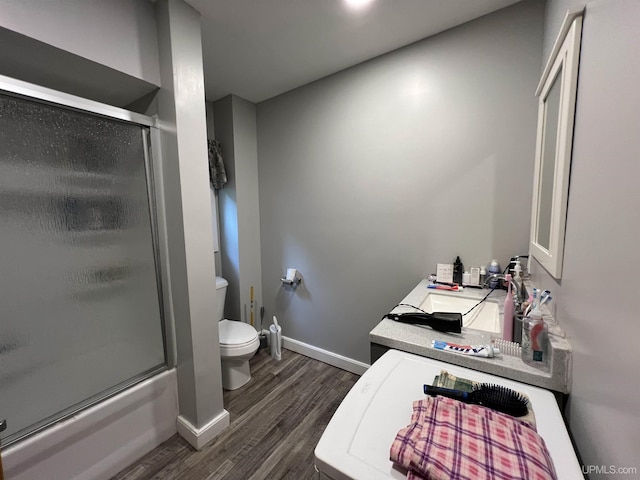 608 W Onota St, Munising, MI 49862 - bathroom featuring wood finished floors, vanity, and bath / shower combo with glass door
