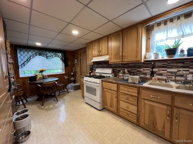 608 W Onota St, Munising, MI 49862 - kitchen featuring white range with gas cooktop, under cabinet range hood, brown cabinets, a paneled ceiling, and light flooring