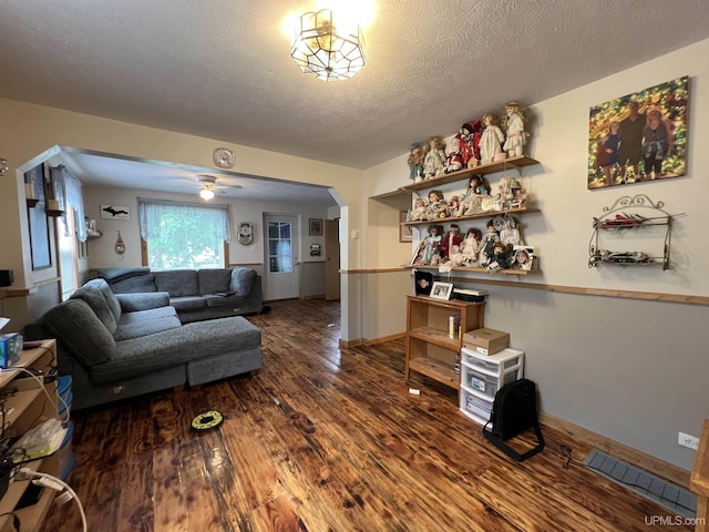 608 W Onota St, Munising, MI 49862 - living area featuring arched walkways, wood finished floors, a textured ceiling, and a ceiling fan