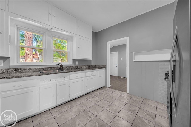 1118 Bancroft St, Port Huron, MI 48060 - kitchen with stainless steel fridge with ice dispenser, white cabinetry, dark stone countertops, crown molding, and light tile patterned floors