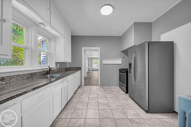 1118 Bancroft St, Port Huron, MI 48060 - kitchen with appliances with stainless steel finishes, white cabinetry, plenty of natural light, and dark stone countertops