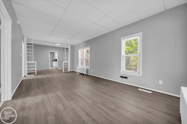1118 Bancroft St, Port Huron, MI 48060 - unfurnished living room with radiator, wood finished floors, and a paneled ceiling