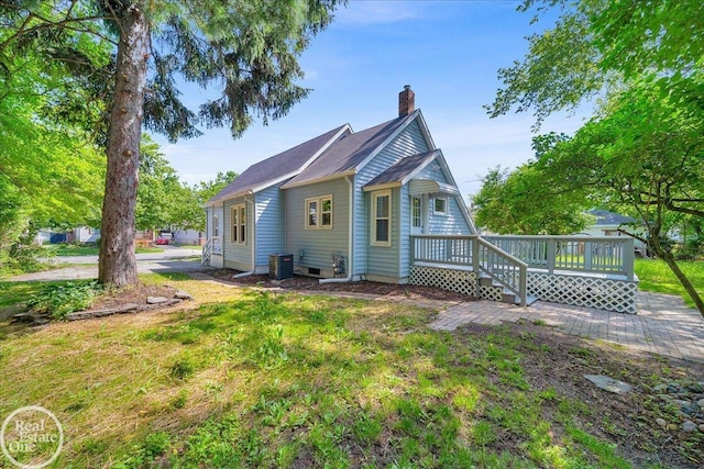 1118 Bancroft St, Port Huron, MI 48060 - back of property with a chimney, a wooden deck, and a lawn