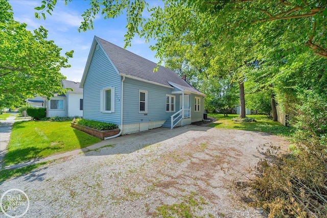 1118 Bancroft St, Port Huron, MI 48060 - view of property exterior featuring a shingled roof, entry steps, driveway, and a yard
