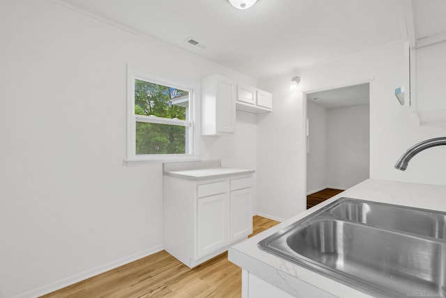 1404 Pine St, Port Huron, MI 48060 - kitchen featuring light wood-type flooring, light countertops, and white cabinetry