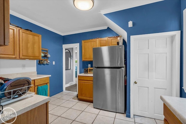 2019 Griswold St, Port Huron, MI 48060 - kitchen with freestanding refrigerator, light countertops, light tile patterned floors, crown molding, and brown cabinetry