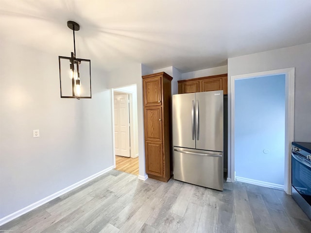 26315 Ursuline St, Saint Clair Shores, MI 48081 - kitchen with appliances with stainless steel finishes, light wood-style flooring, brown cabinets, and decorative light fixtures