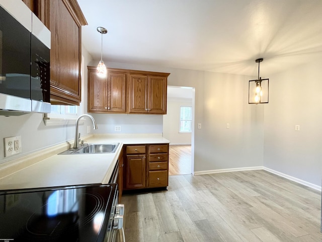 26315 Ursuline St, Saint Clair Shores, MI 48081 - kitchen featuring stainless steel microwave, electric stove, light wood finished floors, brown cabinetry, and light countertops