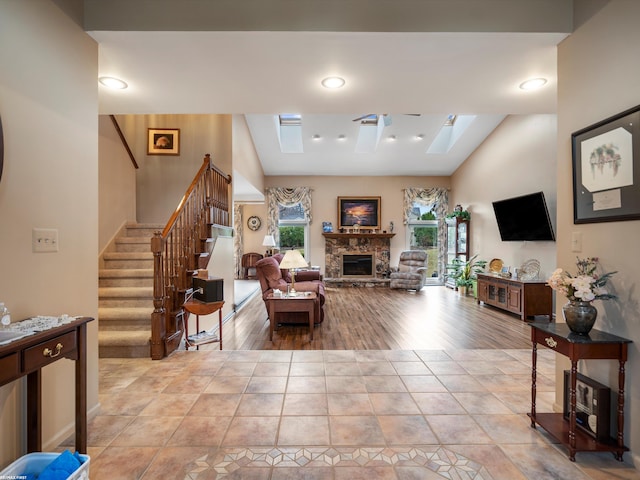 1008 Hidden Ln, Rochester Hills, MI 48309 - living area with a skylight, stairs, a stone fireplace, lofted ceiling, and light tile patterned flooring