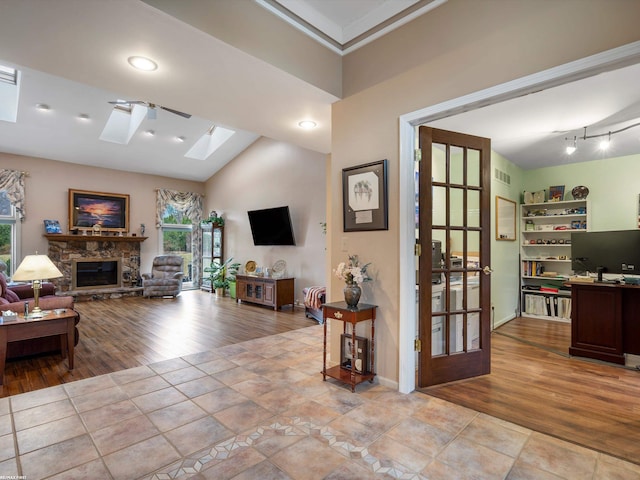 1008 Hidden Ln, Rochester Hills, MI 48309 - living area with a skylight, wood finished floors, a stone fireplace, ornamental molding, and a desk