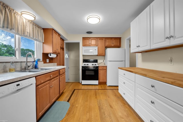 23716 Roxana Ave, Eastpointe, MI 48021 - kitchen with white appliances, light wood-style flooring, white cabinets, and brown cabinets