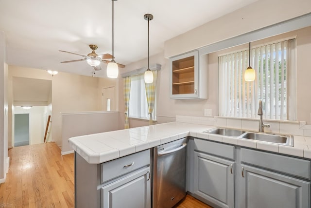 6575 Goldfinch Ln, Clarkston, MI 48346 - kitchen with stainless steel dishwasher, gray cabinets, a peninsula, ceiling fan, and glass insert cabinets