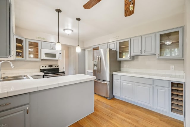 6575 Goldfinch Ln, Clarkston, MI 48346 - kitchen with stainless steel appliances, gray cabinets, tile countertops, light wood finished floors, and a ceiling fan