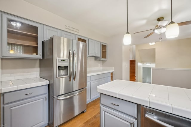 6575 Goldfinch Ln, Clarkston, MI 48346 - kitchen with appliances with stainless steel finishes, gray cabinetry, ceiling fan, light wood-style floors, and glass insert cabinets