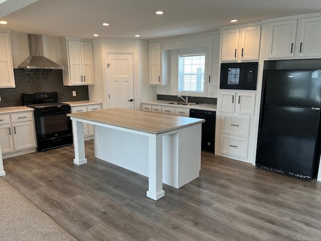 264 Westbrook Ct, Port Huron, MI 48060 - kitchen with black appliances, wall chimney exhaust hood, recessed lighting, white cabinetry, and dark wood-style flooring