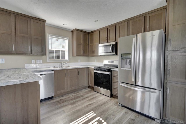 260 Meadow Ln, Port Huron, MI 48060 - kitchen featuring appliances with stainless steel finishes, light wood-style floors, light countertops, and a textured ceiling