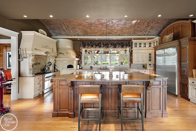 5350 Brewster Rd, Oakland Twp, MI 48306 - kitchen featuring high quality appliances, brick ceiling, custom range hood, glass insert cabinets, and tasteful backsplash
