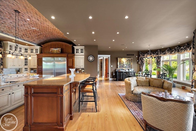 5350 Brewster Rd, Oakland Twp, MI 48306 - kitchen with built in fridge, glass insert cabinets, light stone countertops, a spacious island, and lofted ceiling