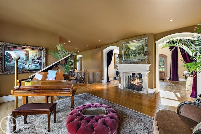 5350 Brewster Rd, Oakland Twp, MI 48306 - living room featuring arched walkways, wood finished floors, recessed lighting, and a fireplace with flush hearth