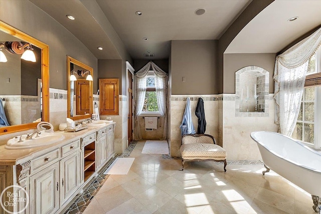 5350 Brewster Rd, Oakland Twp, MI 48306 - full bathroom featuring tile walls, a wainscoted wall, a freestanding bath, double vanity, and recessed lighting