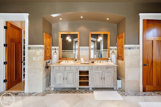 5350 Brewster Rd, Oakland Twp, MI 48306 - bathroom with tile walls, double vanity, wainscoting, recessed lighting, and vaulted ceiling