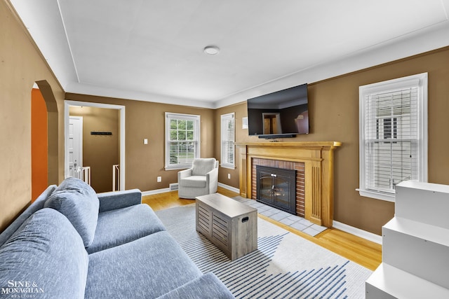 1857 Roslyn Rd, Grosse Pointe Woods, MI 48236 - living area featuring a brick fireplace, light wood finished floors, and arched walkways