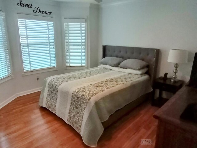 2308 S River Rd, Beaverton, MI 48612 - bedroom featuring wood finished floors, multiple windows, and ornamental molding