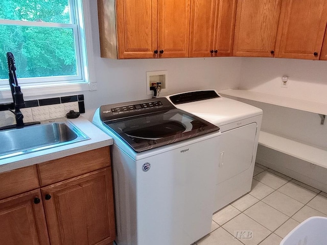 2308 S River Rd, Beaverton, MI 48612 - washroom with cabinet space, washer and dryer, and light tile patterned flooring