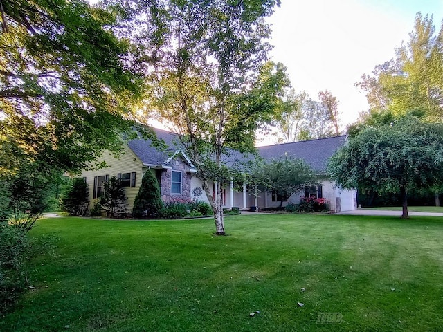 2308 S River Rd, Beaverton, MI 48612 - view of front of house featuring a front lawn, stone siding, and roof with shingles