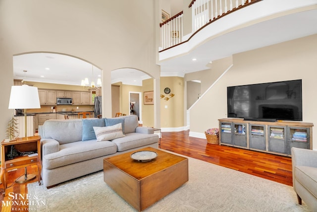 3325 Saint Andrews Dr, Port Huron, MI 48060 - living room with arched walkways, light wood-style flooring, a high ceiling, crown molding, and recessed lighting